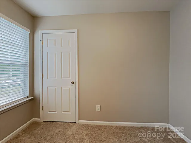 an empty room with closet area and glass door