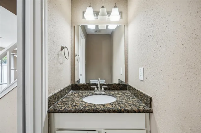 a bathroom with a granite countertop sink and a mirror