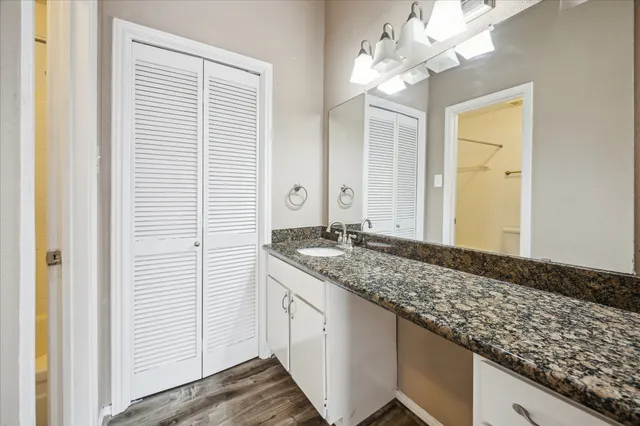 a bathroom with a granite countertop sink and a mirror