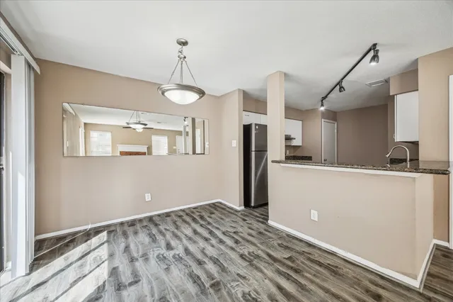 a view of a kitchen with wooden floor and a ceiling fan