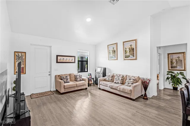 a living room with furniture a wooden floor and next to a window