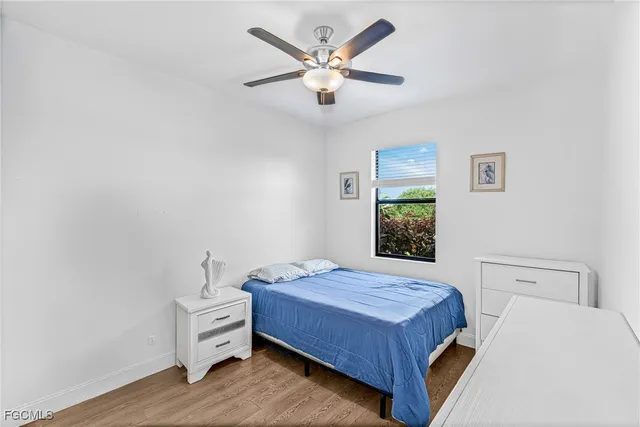 an empty room with a wooden floor and ceiling fan