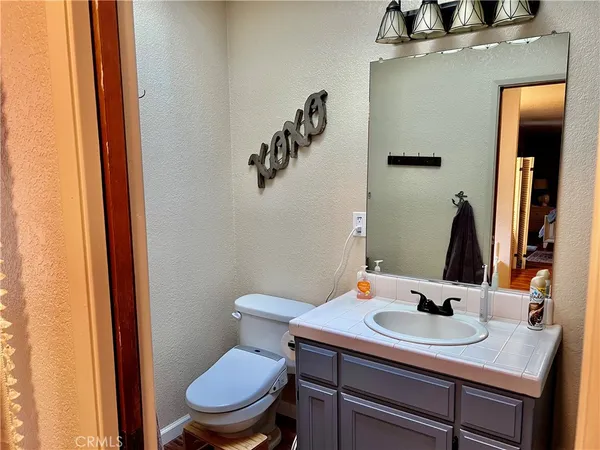 a bathroom with a sink vanity mirror and toilet