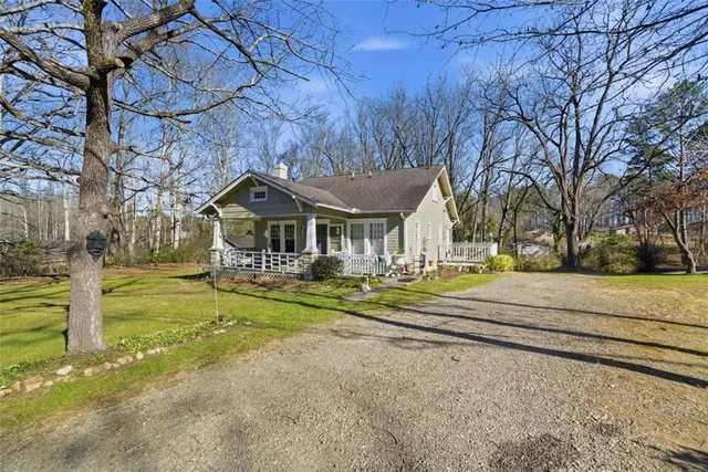 a front view of house with a garden and trees