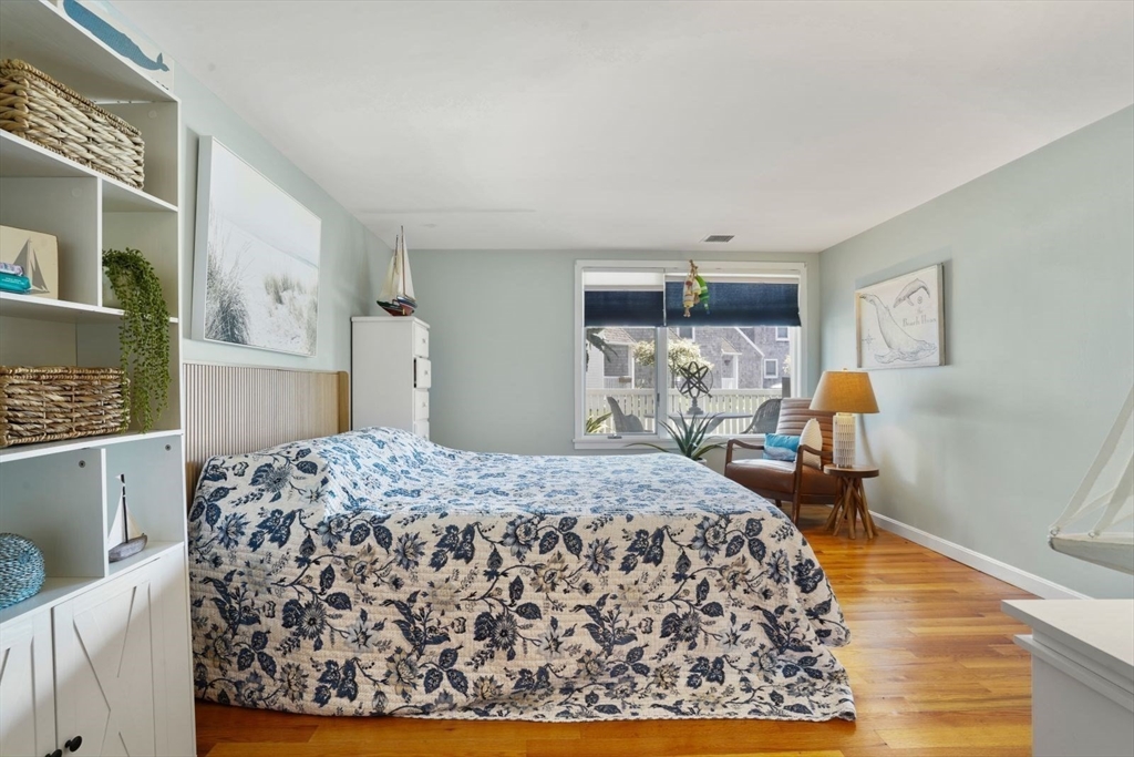 1 Commodore Court, Unit 104 Hull, MA 02045 - Photo 20 of 35 a bedroom with a bed and wooden floor