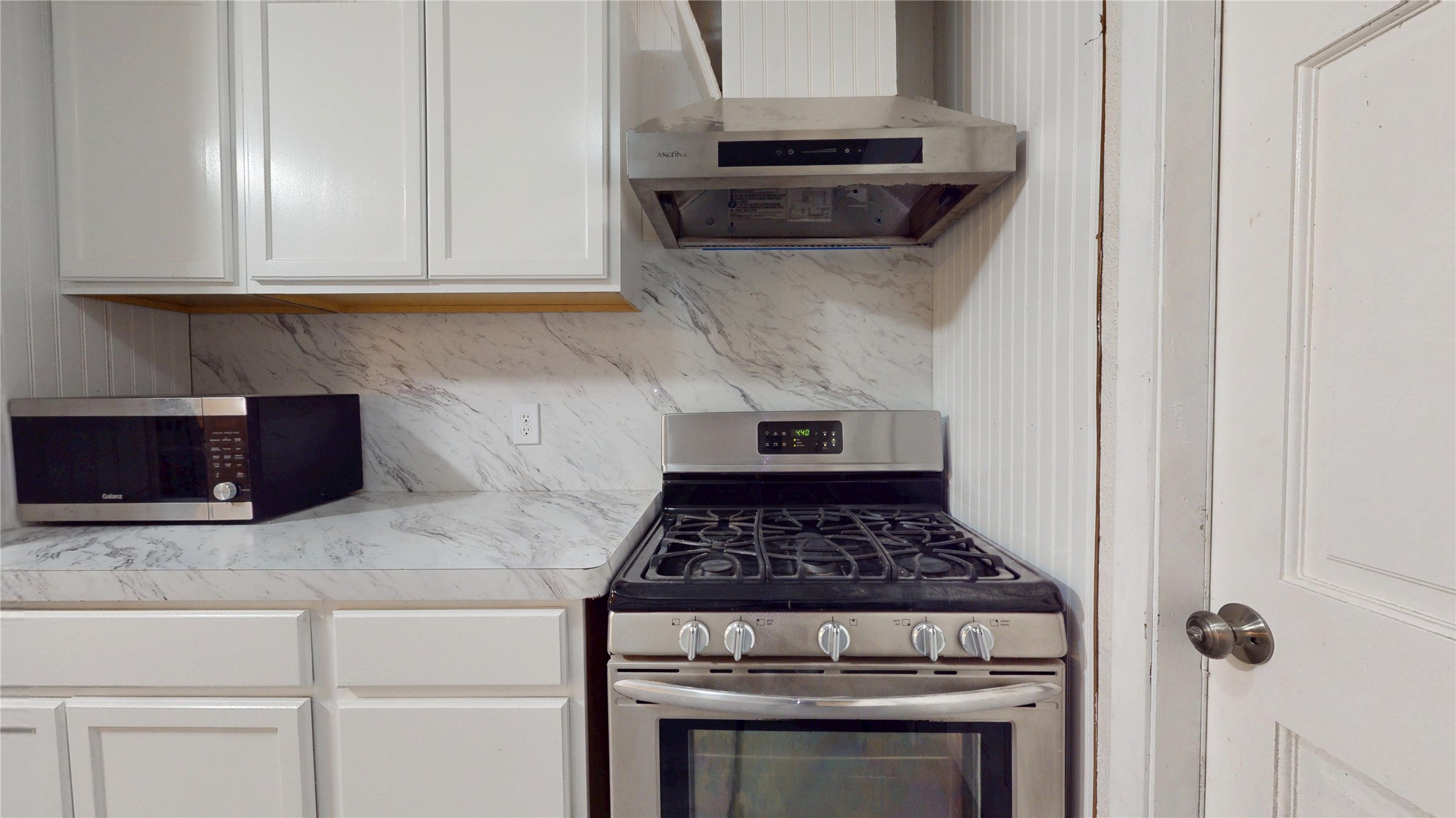 7115 Inkberry Drive Houston, TX 77092 - Photo 11 of 31 a kitchen with stainless steel appliances granite countertop white cabinets and black appliances