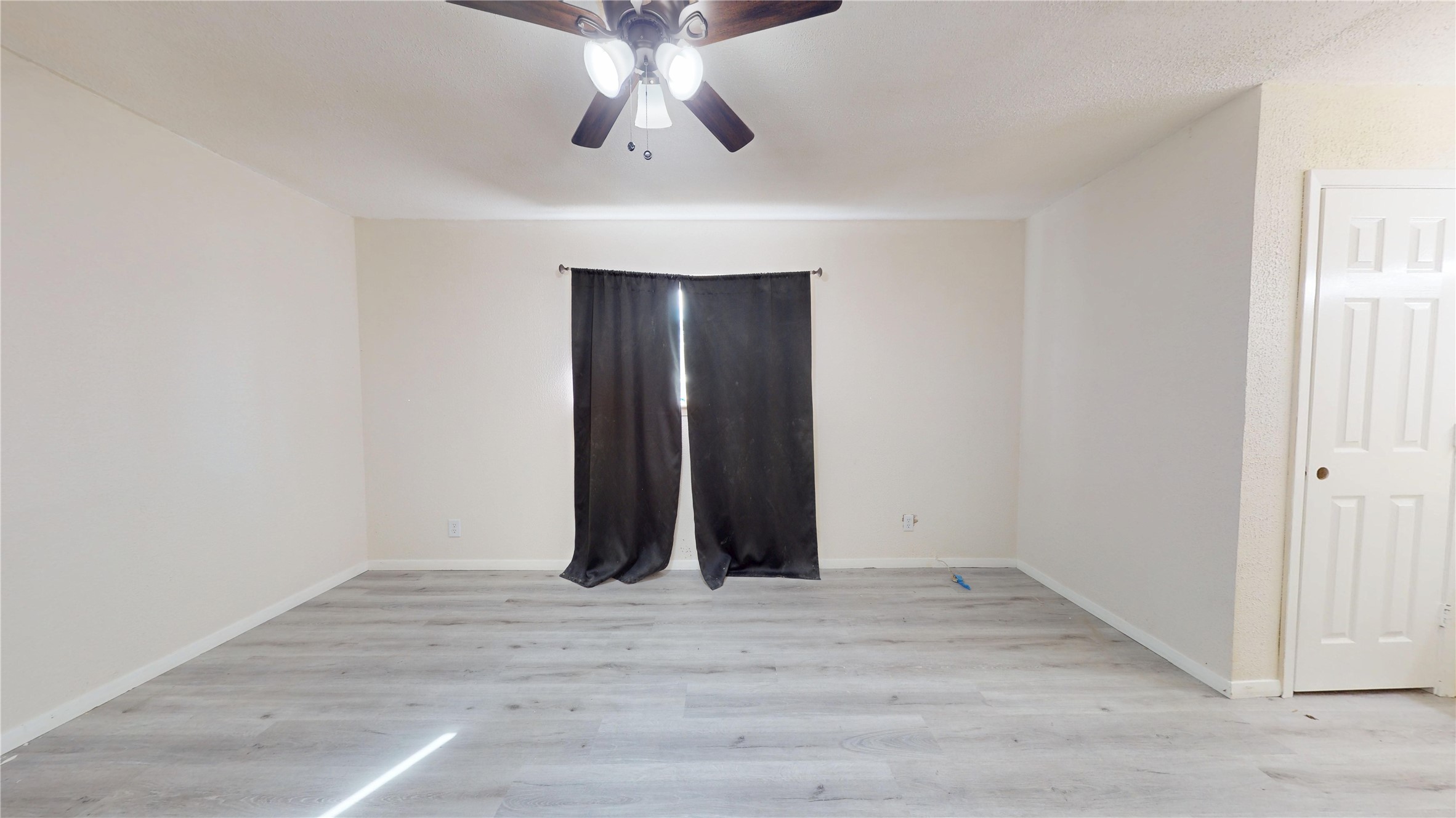 7115 Inkberry Drive Houston, TX 77092 - Photo 27 of 31 an empty room with wooden floor and chandelier fan