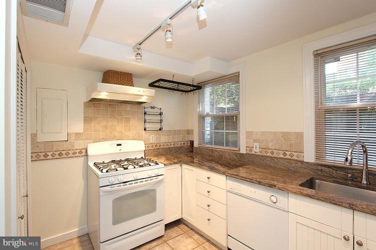 a kitchen with granite countertop cabinets sink appliances and a window