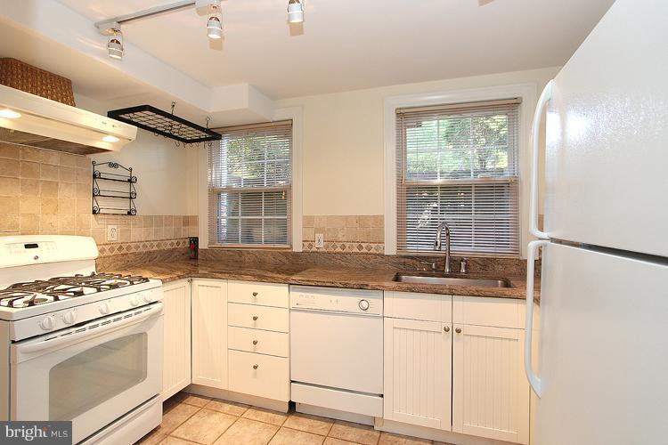 1214 Portner Road Alexandria, VA 22314 - Photo 17 of 21 a kitchen with granite countertop white cabinets and white appliances