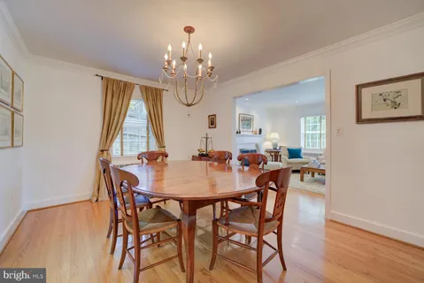 a view of a dining room with furniture a chandelier and wooden floor