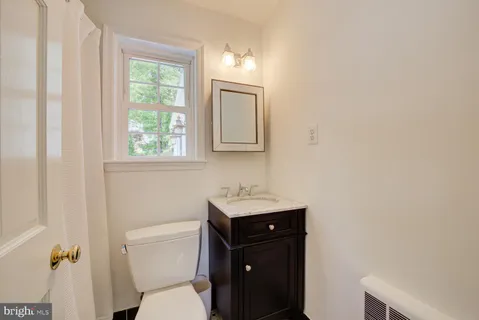 a bathroom with a toilet a sink and mirror