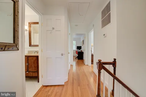 a view of a hallway with wooden floor and staircase