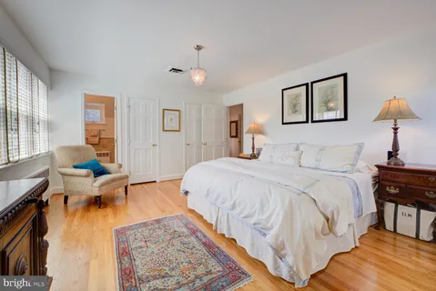 a spacious bedroom with a bed and wooden floor