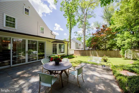 a view of a patio with table and chairs and floor to ceiling window