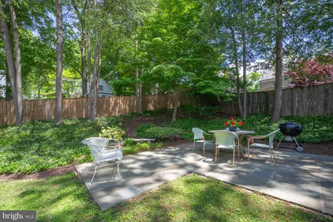 a view of a chair and table in backyard of the house