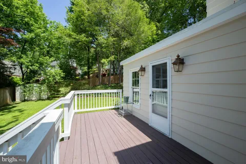 a view of deck with a large trees and wooden fence
