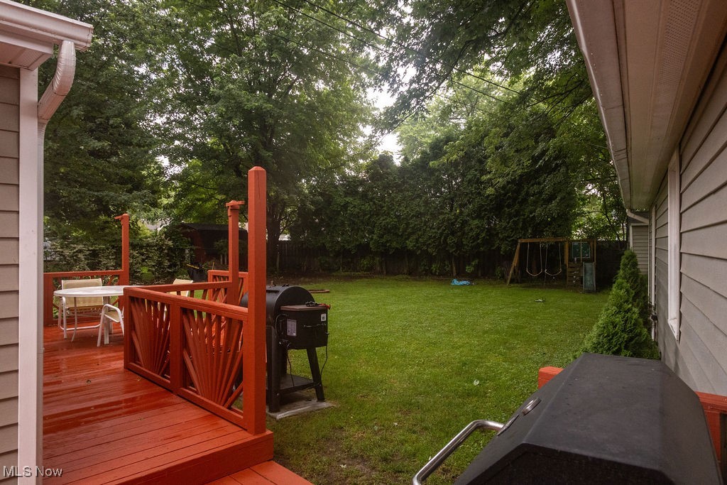 1995 Benjamin Road Madison, OH 44057 - Photo 8 of 50 Fenced backyard with a wooden deck and a playground