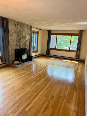 wooden floor fireplace and windows in an empty room