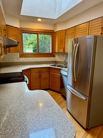a kitchen with stainless steel appliances granite countertop a refrigerator and a sink