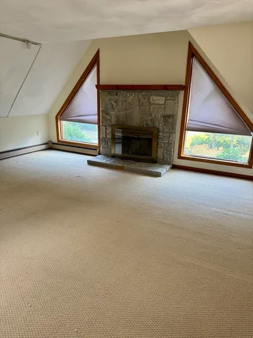 a view of empty room with fireplace and window