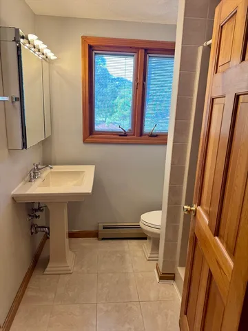 a bathroom with a sink toilet and a mirror