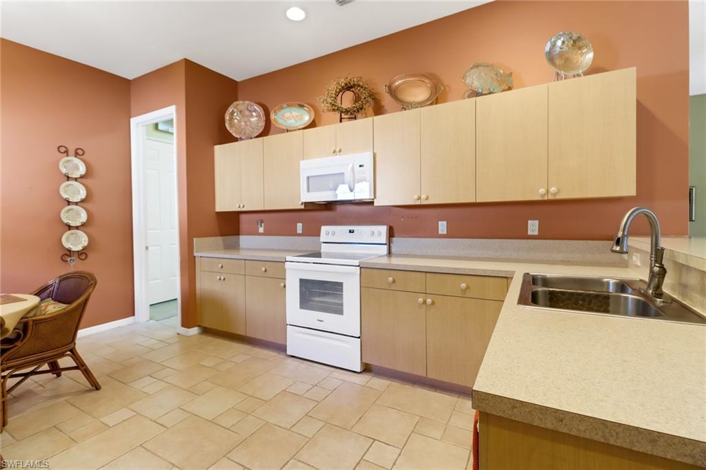 9312 Sun River Way Estero, FL 33928 - Photo 11 of 45 a kitchen that has a sink and a stove in it