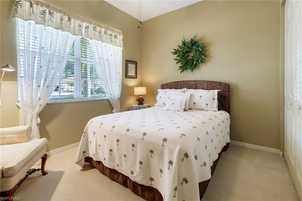 9312 Sun River Way Estero, FL 33928 - Photo 15 of 45 a bedroom with a bed and a chandelier