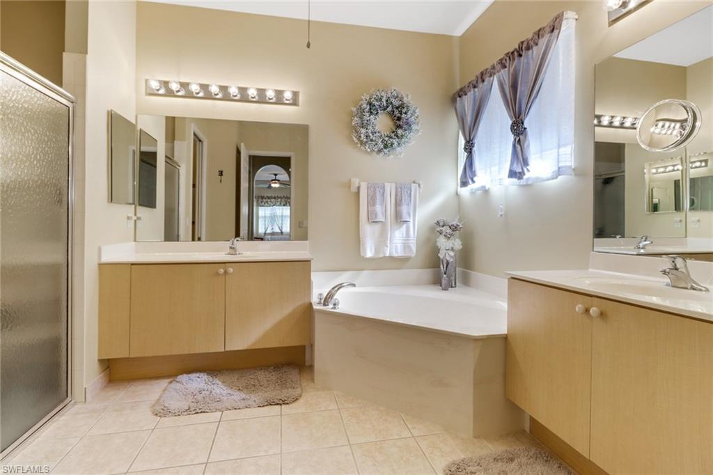 9312 Sun River Way Estero, FL 33928 - Photo 20 of 45 a bathroom with a tub sink and mirror