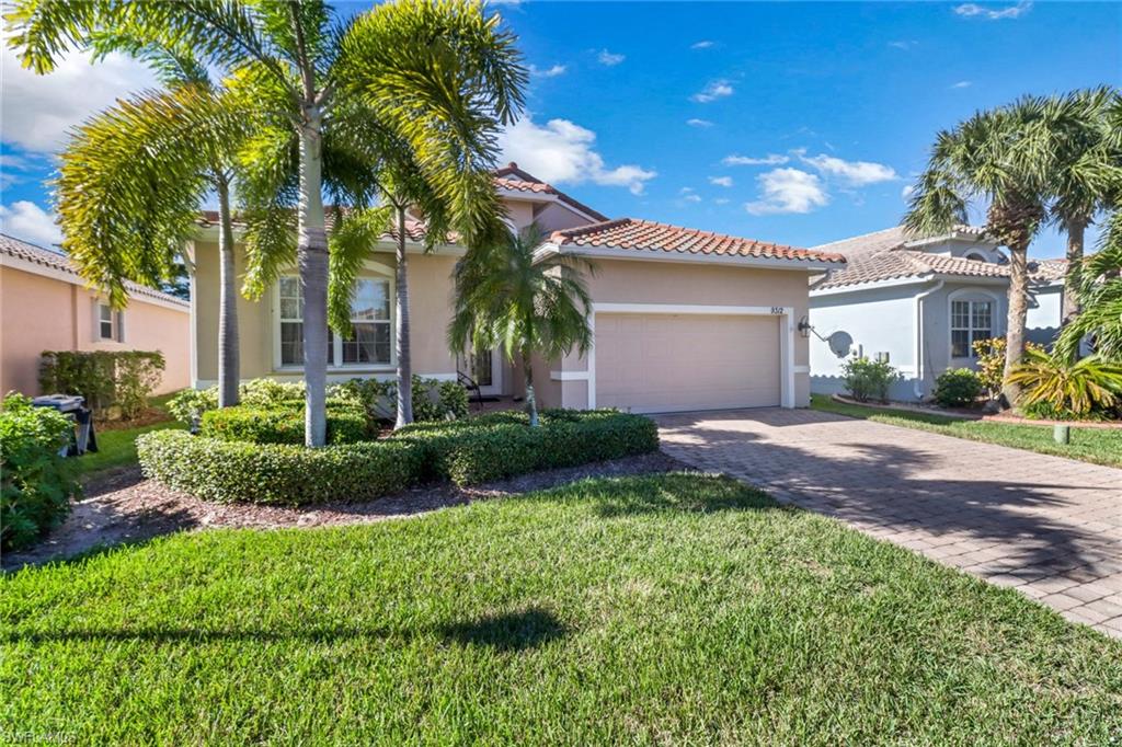 9312 Sun River Way Estero, FL 33928 - Photo 2 of 45 a view of a house with a yard and palm trees