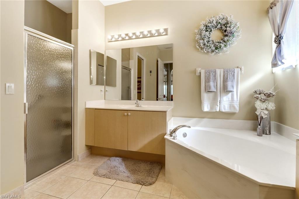 9312 Sun River Way Estero, FL 33928 - Photo 21 of 45 a bathroom with a tub sink and mirror