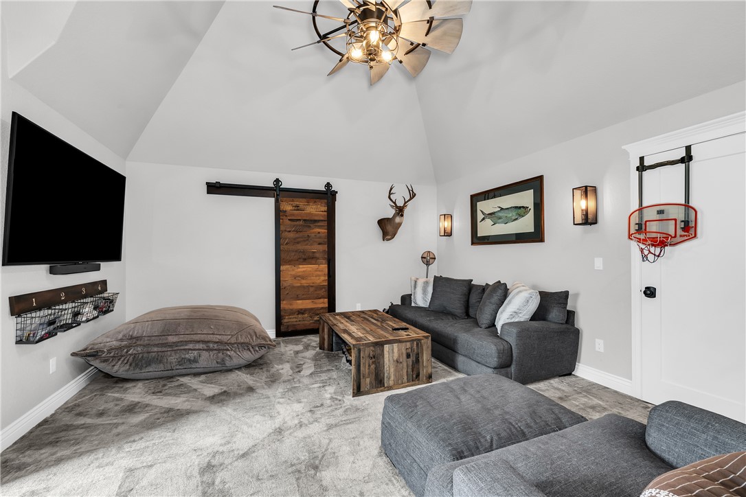 3510 Copper Ridge Road Rogers, AR 72756 - Photo 28 of 58 This spacious room features vaulted ceilings, light gray walls, and a large ceiling fan with an industrial design