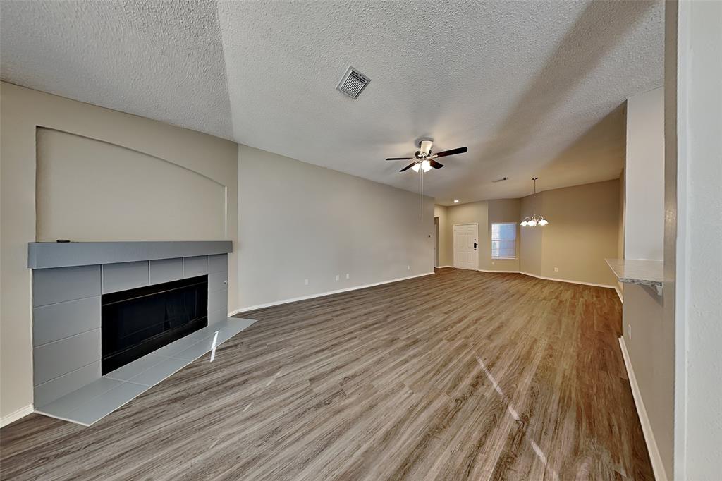 3304 Athens Drive Corinth, TX 76210 - Photo 3 of 22 a view of an empty room with wooden floor and fireplace
