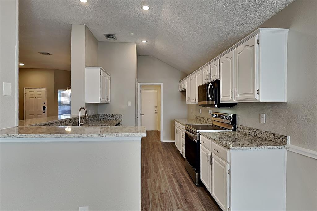 3304 Athens Drive Corinth, TX 76210 - Photo 5 of 22 a kitchen with stainless steel appliances granite countertop a sink stove microwave and refrigerator
