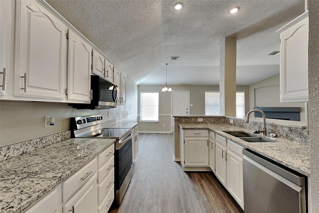 3304 Athens Drive Corinth, TX 76210 - Photo 6 of 22 a kitchen with stainless steel appliances granite countertop a sink stove and refrigerator