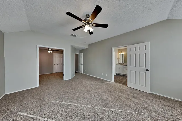 a view of an empty room with a ceiling fan
