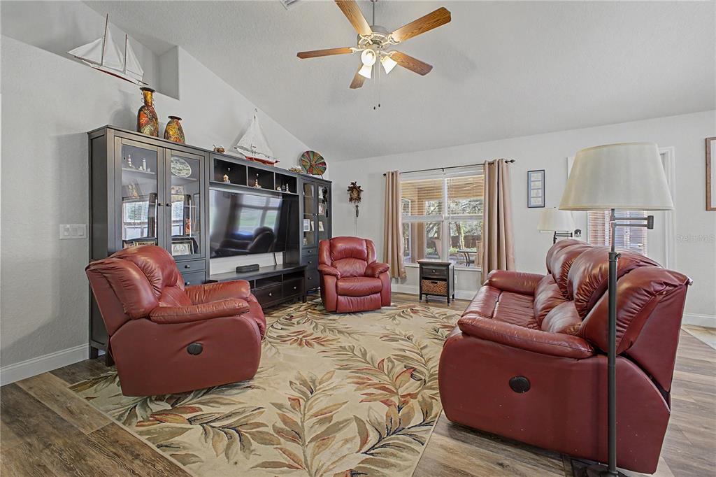11213 Flock Avenue Weeki Wachee, FL 34613 - Photo 14 of 46 a living room with furniture a flat screen tv and a large window