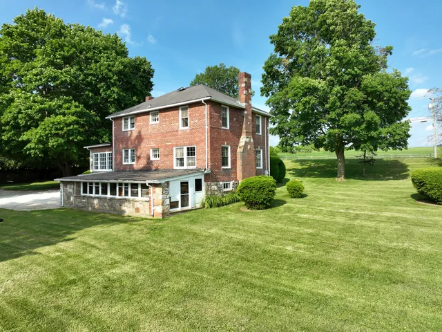 a view of a house with a yard and sitting area