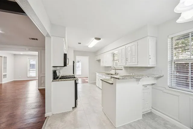 a kitchen with appliances a sink and cabinets