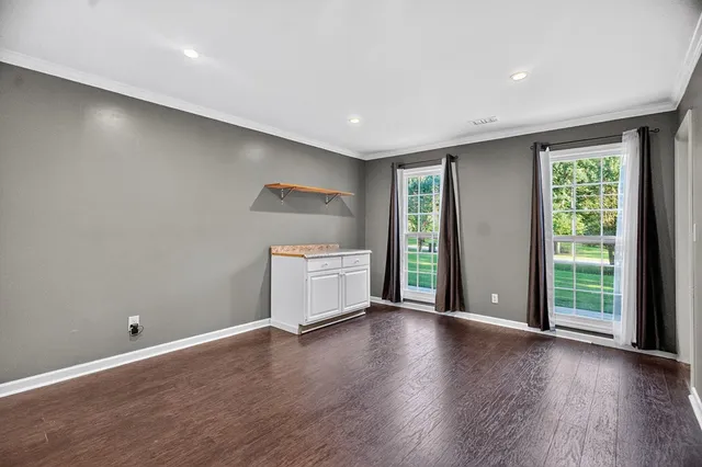 a view of a room with wooden floor and window