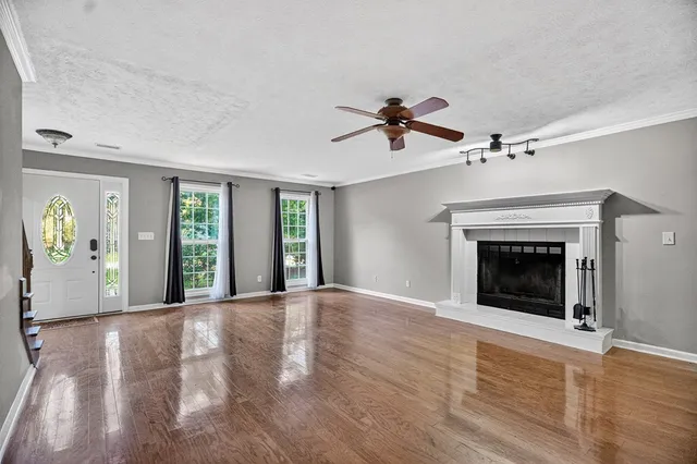 a view of an empty room with window and fire place