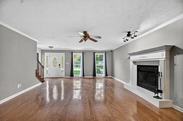 a view of an empty room with exposed radiator and fireplace