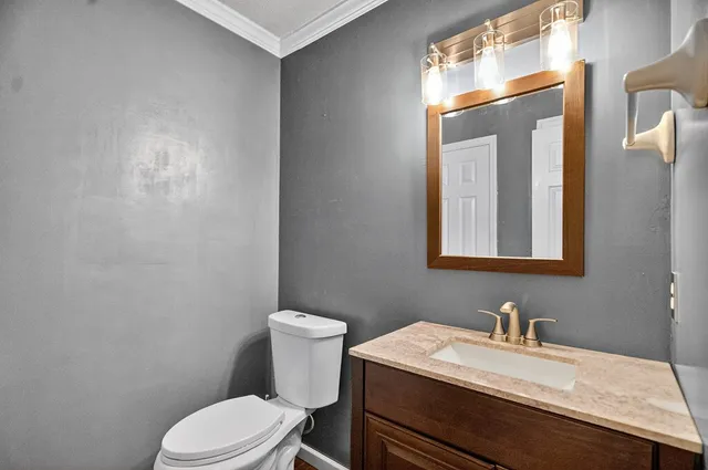 a bathroom with a sink vanity mirror and toilet