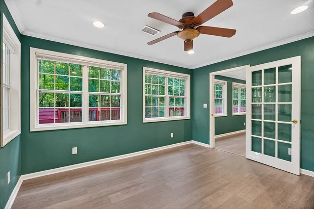 a view of an empty room with a window and a ceiling fan