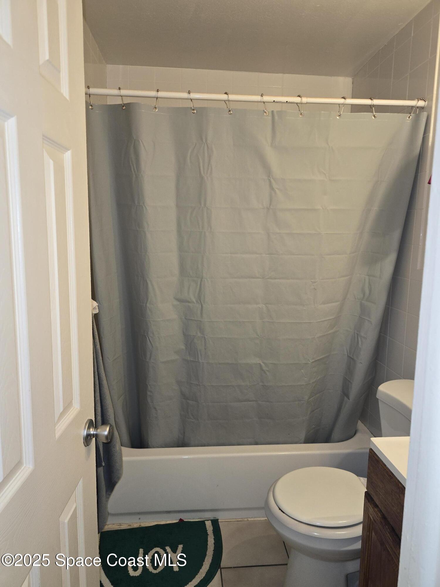 180 Minna Lane, Unit 402 Merritt Island, FL 32953 - Photo 8 of 10 a bathroom with a toilet and a shower curtain