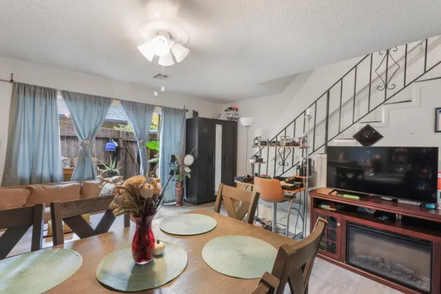 a living room with furniture a flat screen tv and kitchen view