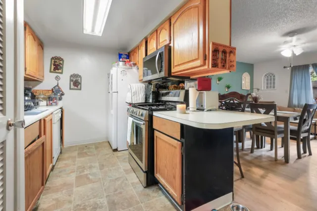 a kitchen with stainless steel appliances granite countertop a stove a sink and a refrigerator