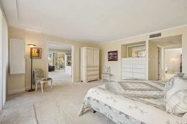 a spacious bedroom with a bed and chair