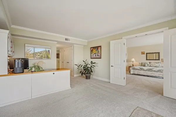 a large white room with a mirror and furniture