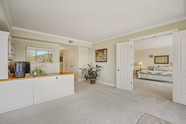 a large white room with a mirror and furniture