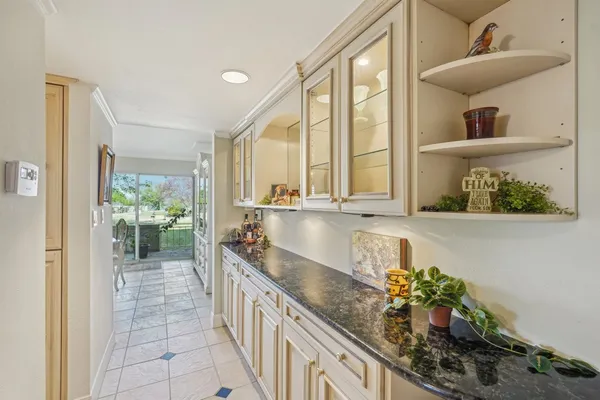 a large white kitchen with a large window and a potted plant